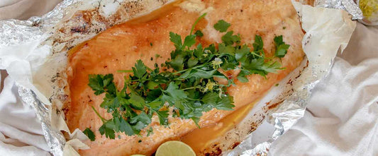 salmon fillet on foil with parsley on top