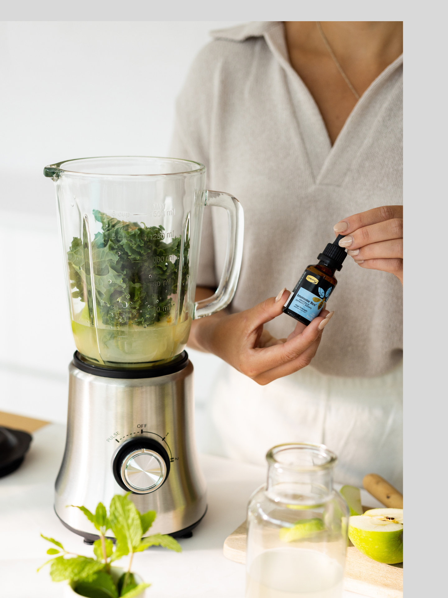 a woman adding bee propolis drops to her smoothy