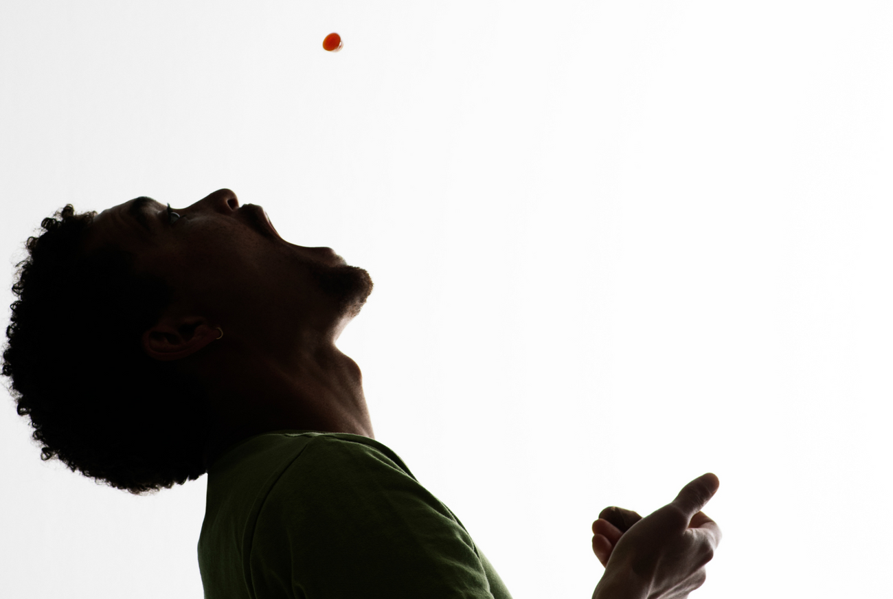 a man catching a manuka honey drop in his mouth