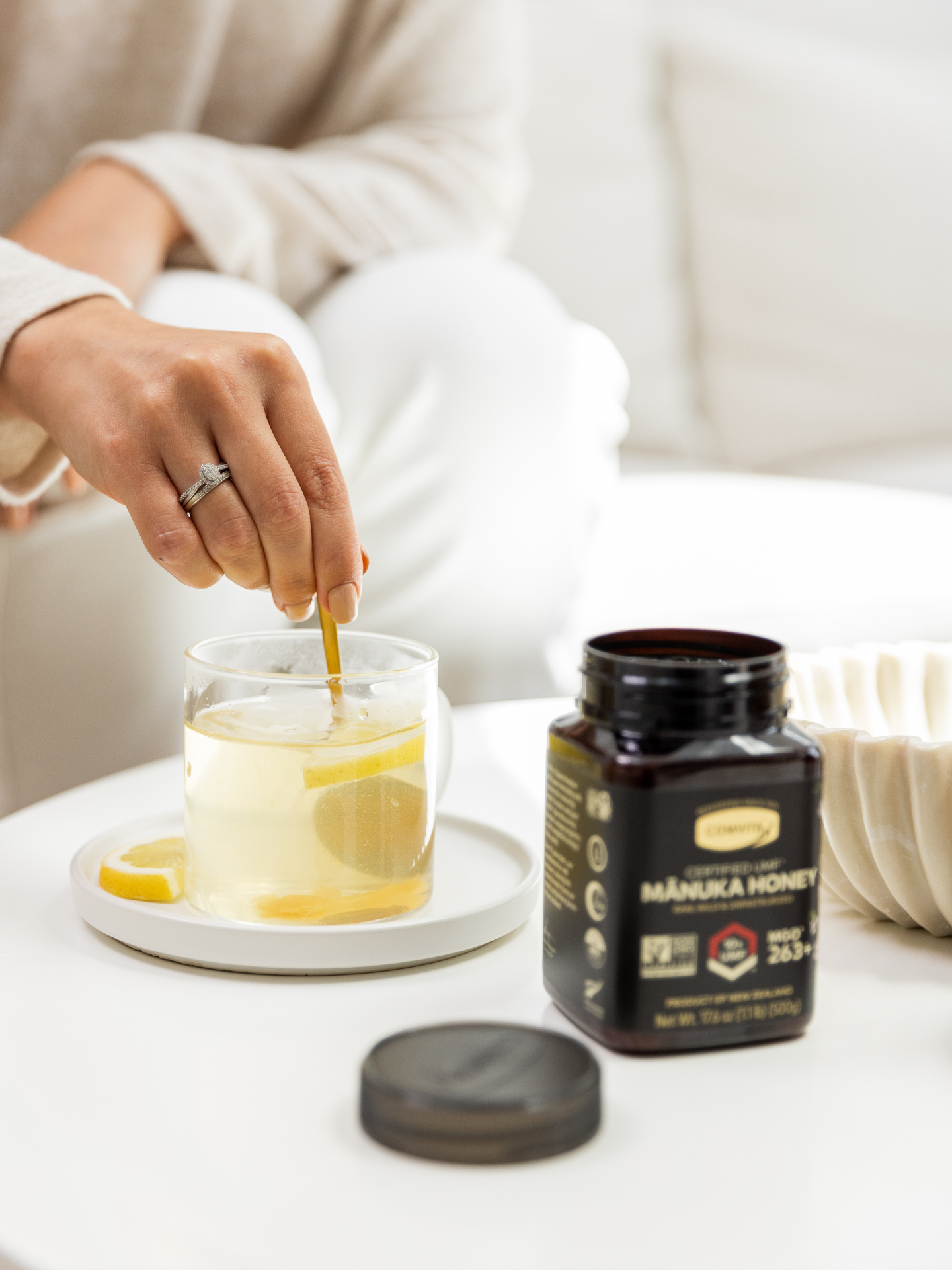a woman stirring manuka honey into her lemon tea
