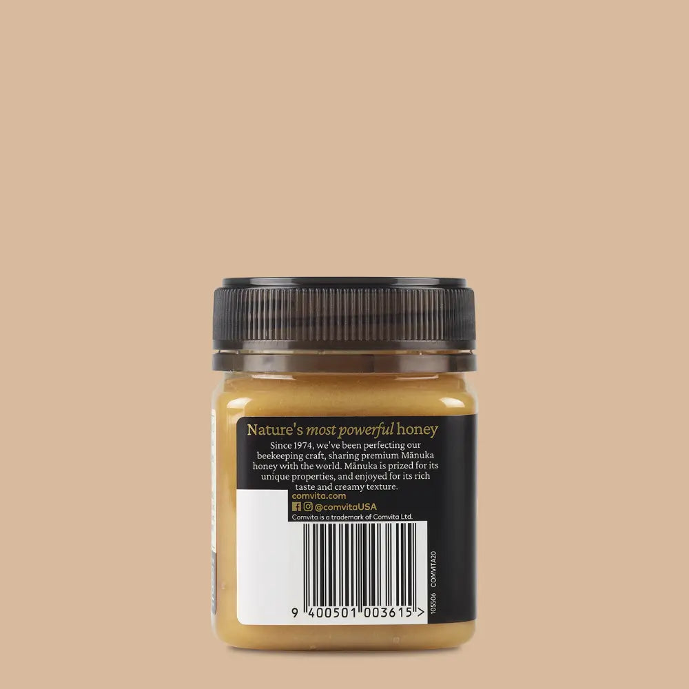 Jar of manuka honey with a black lid on a beige background