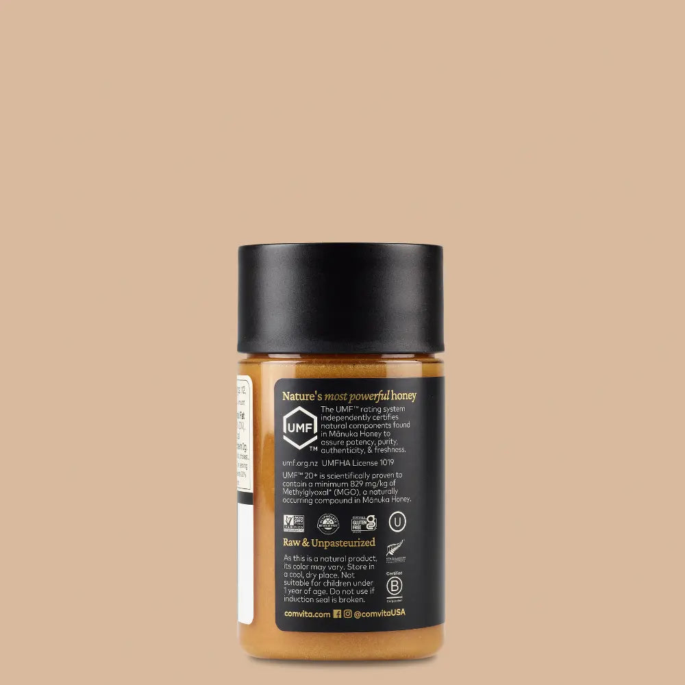 Side label on a jar of Comvita Manuka Honey on a beige background