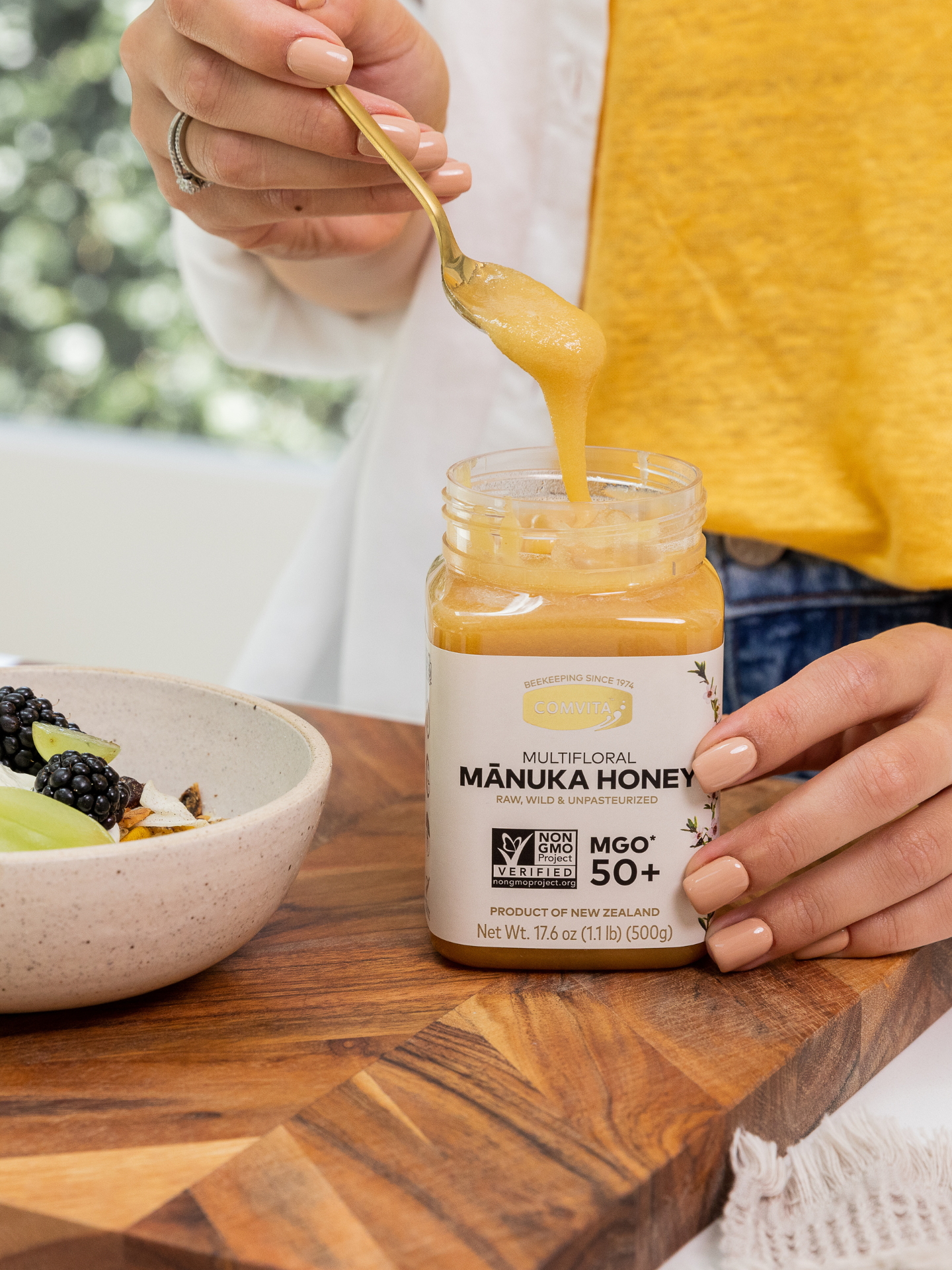 a woman with a spoon of manuka honey mgo 50