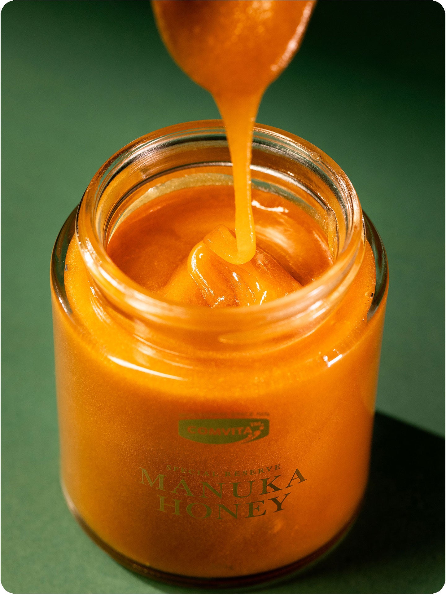 umf 25 manuka honey dripping from spoon into jar
