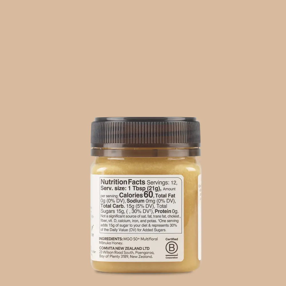 Jar of honey with nutrition label on a beige background