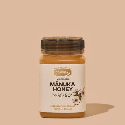 Jar of Manuka Honey with Comvita label on a beige background