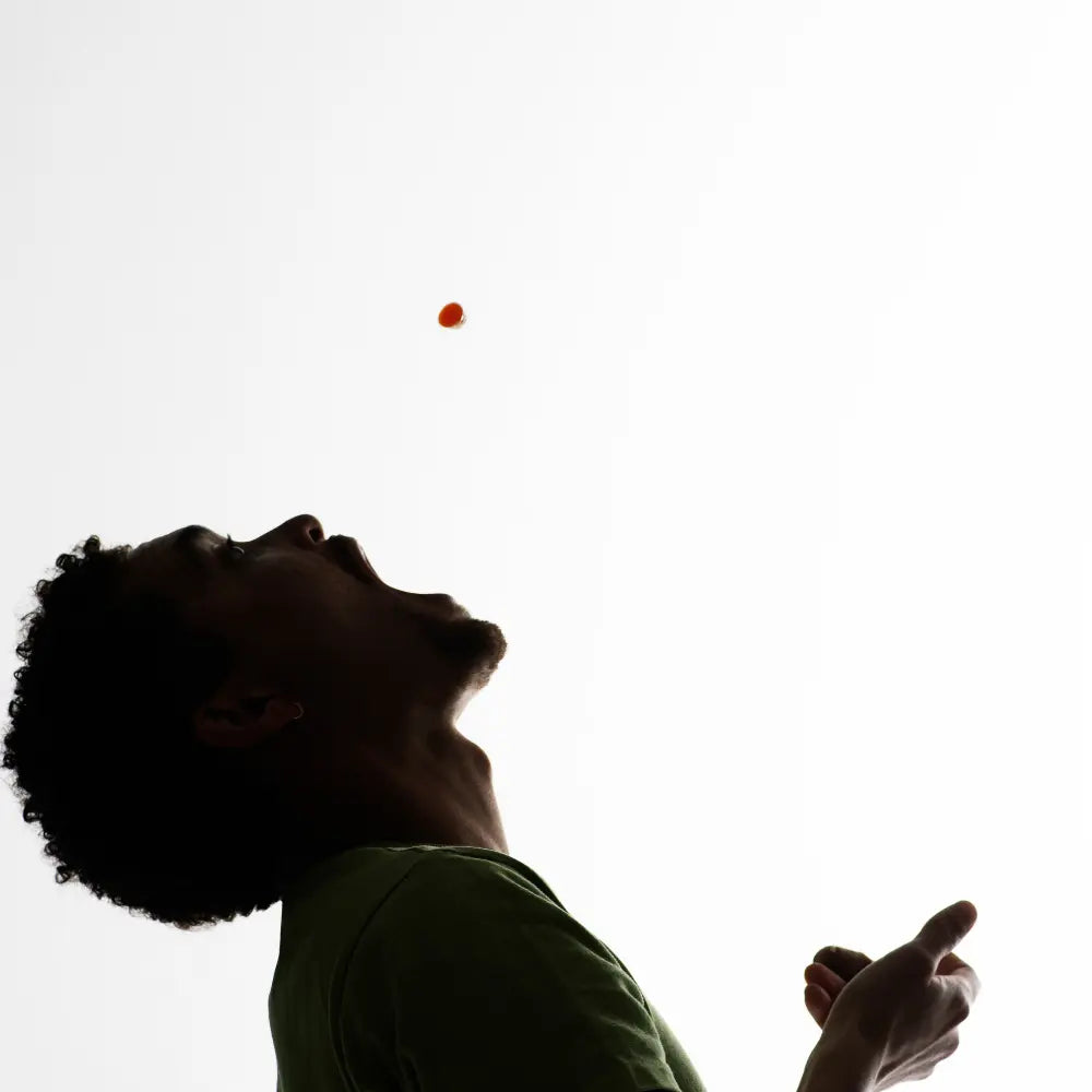 Silhouette of a person catching a honey drop against a white background