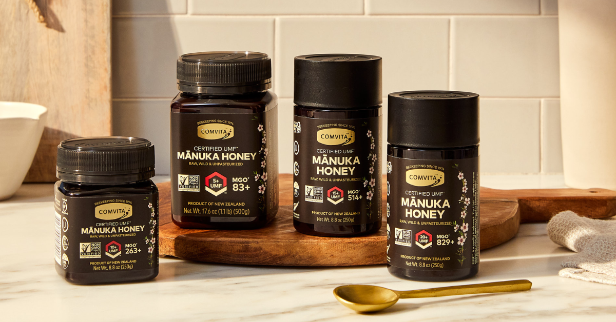 4 umf manuka honey jars on marble table with spoon in front