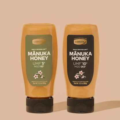 Two bottles of Comvita Manuka Honey on a beige background