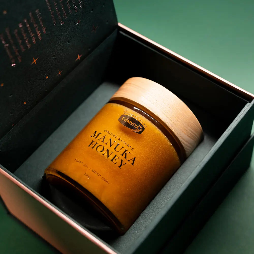 Jar of manuka honey in a gift box on a green background