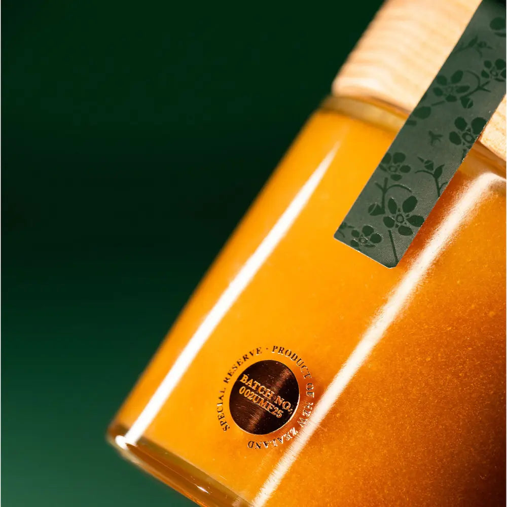 Close-up of a jar with a green label and gold emblem on a dark green background