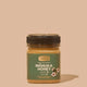 Jar of Comvita Manuka Honey UMF5 on a beige background
