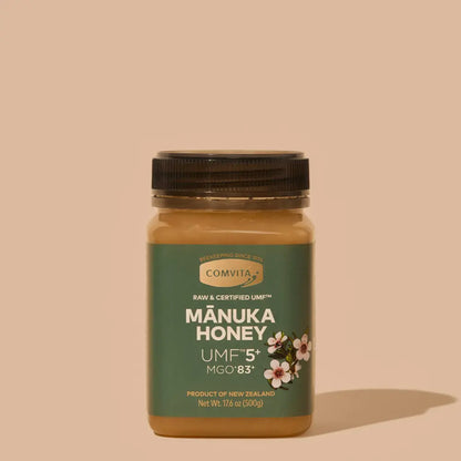 Jar of Comvita Manuka Honey UMF5 on a beige background