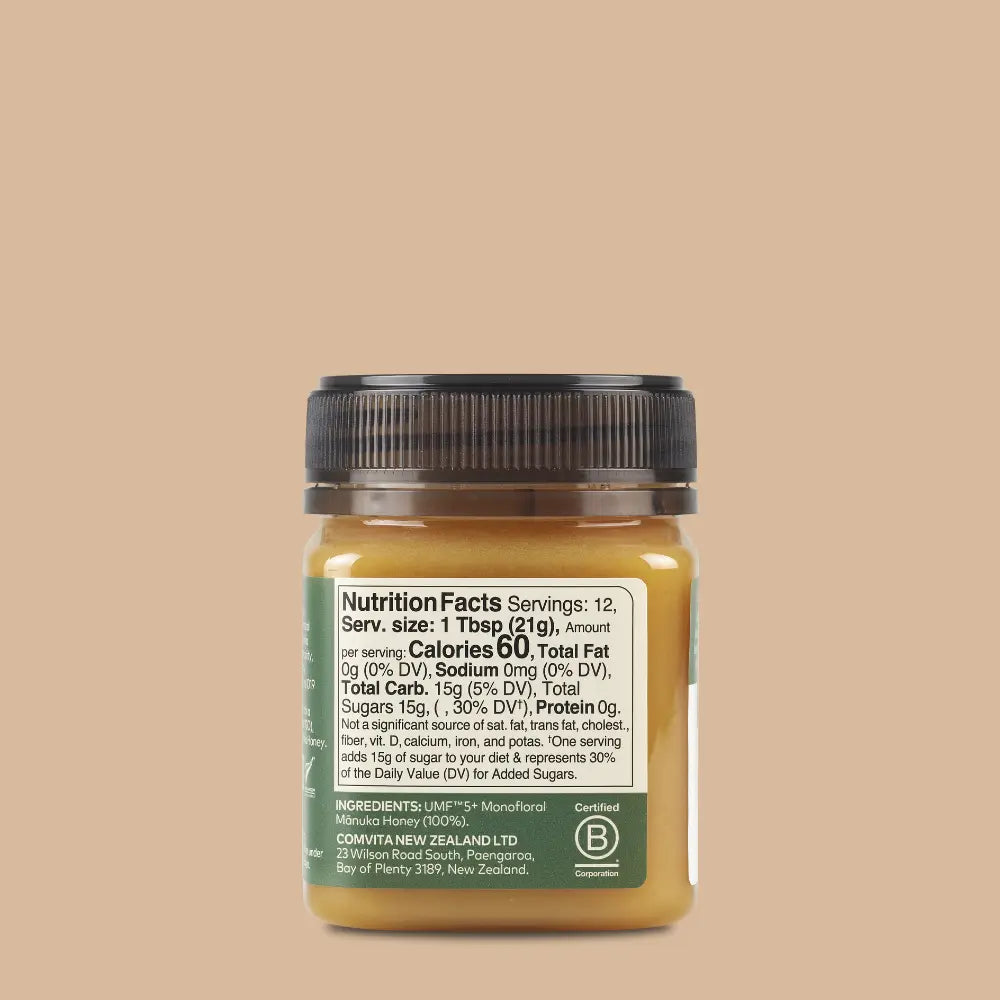 Jar of honey with nutrition label on a beige background