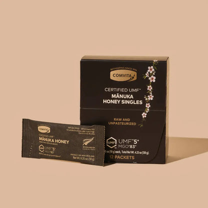 Comvita Manuka Honey 12 pack box package with a single tear pack next to it on a beige background