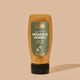 UMF 5 Comvita Manuka honey bottle with green label on a beige background