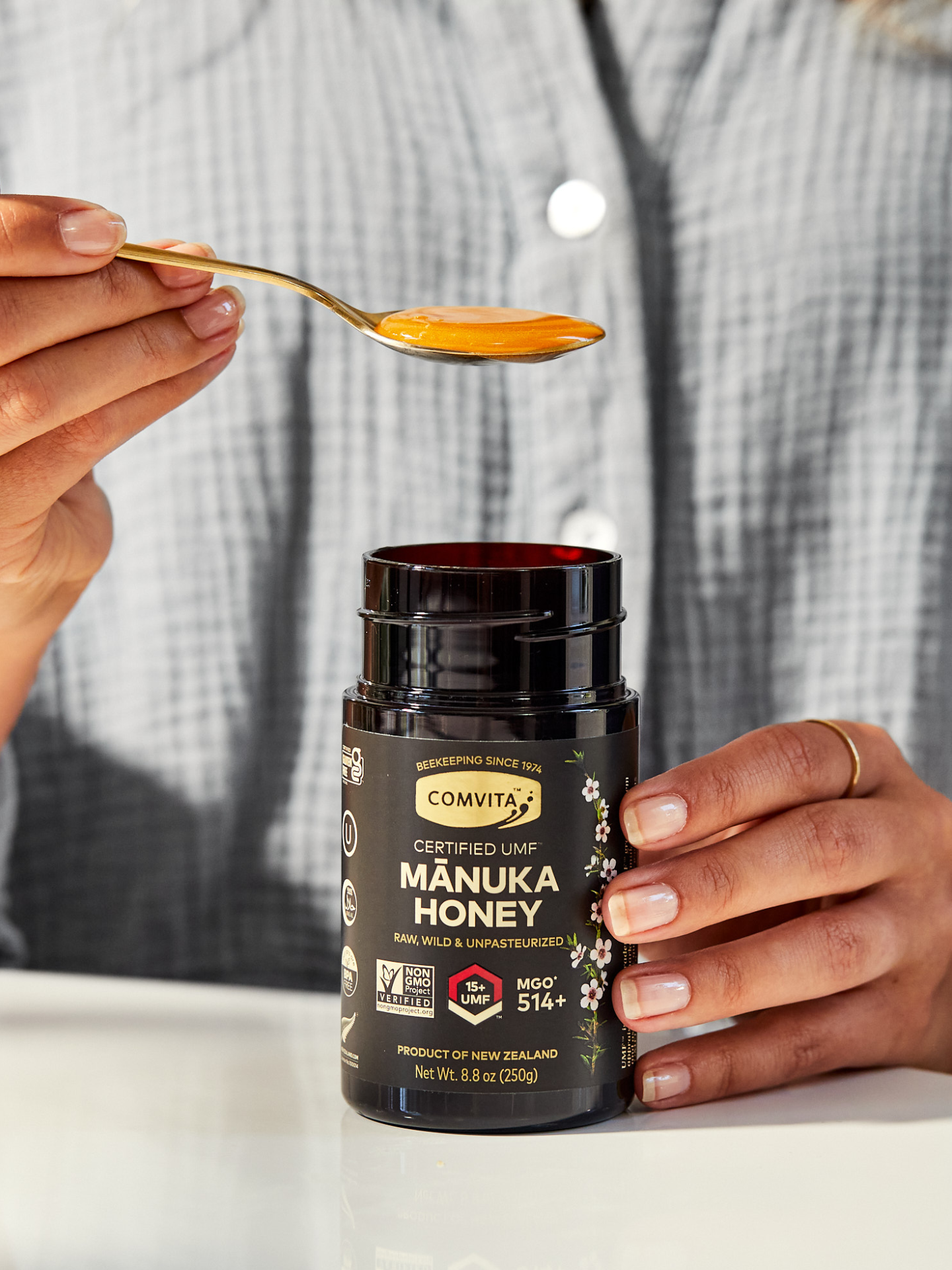 spoonful of honey with hand on jar